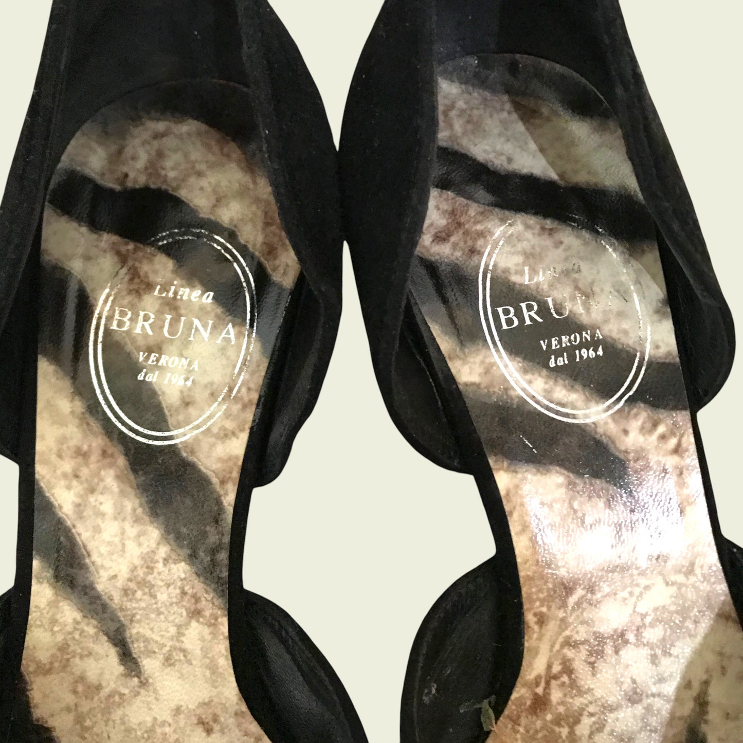 Black suede shoes on beige background