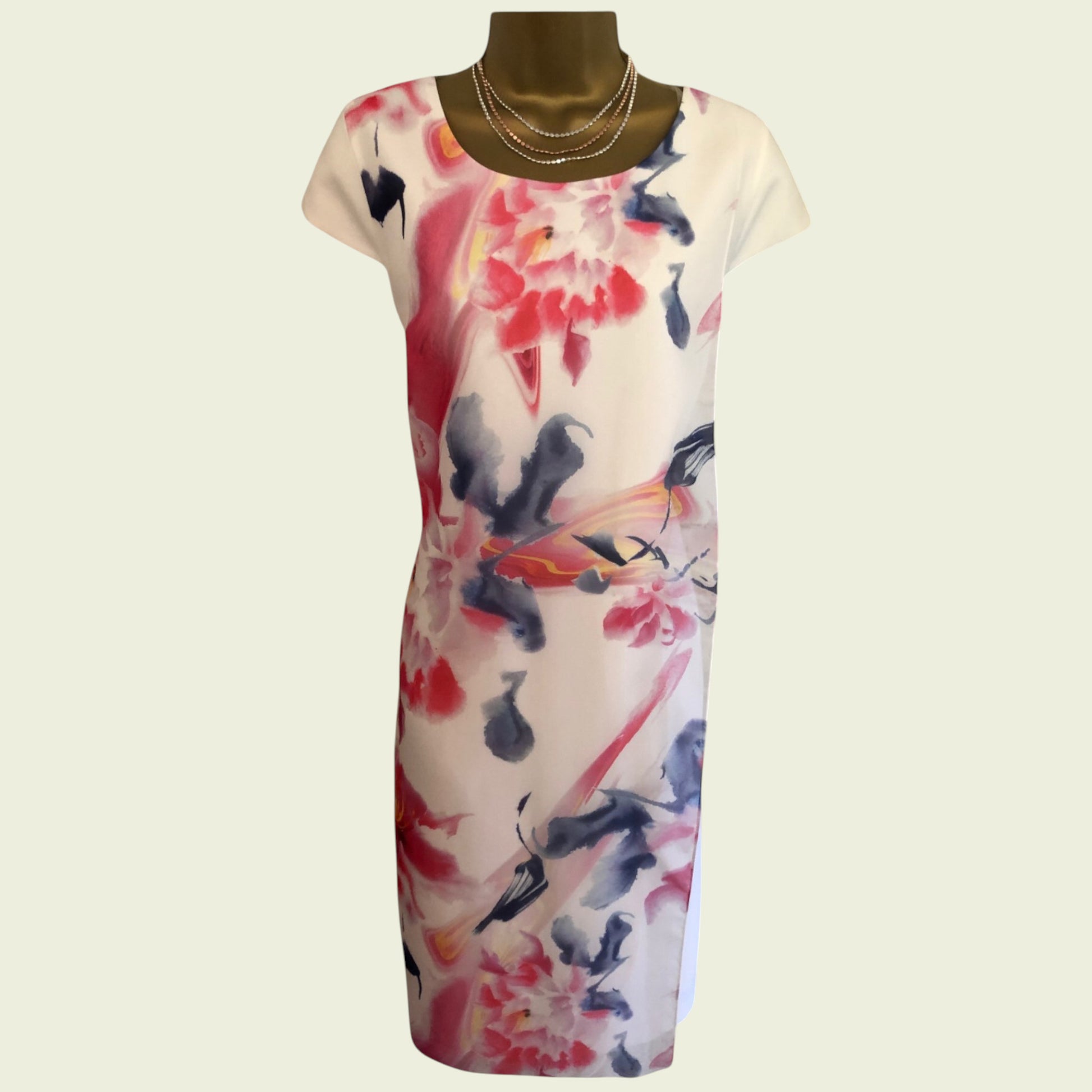 mannequin wearing white and multicoloured floral dress on beige background
