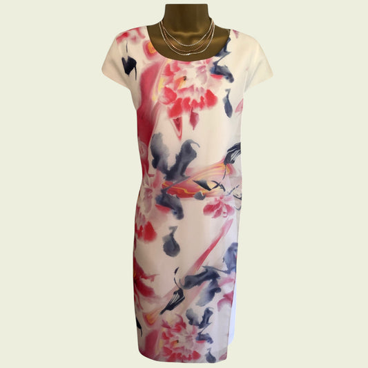 mannequin wearing white and multicoloured floral dress on beige background