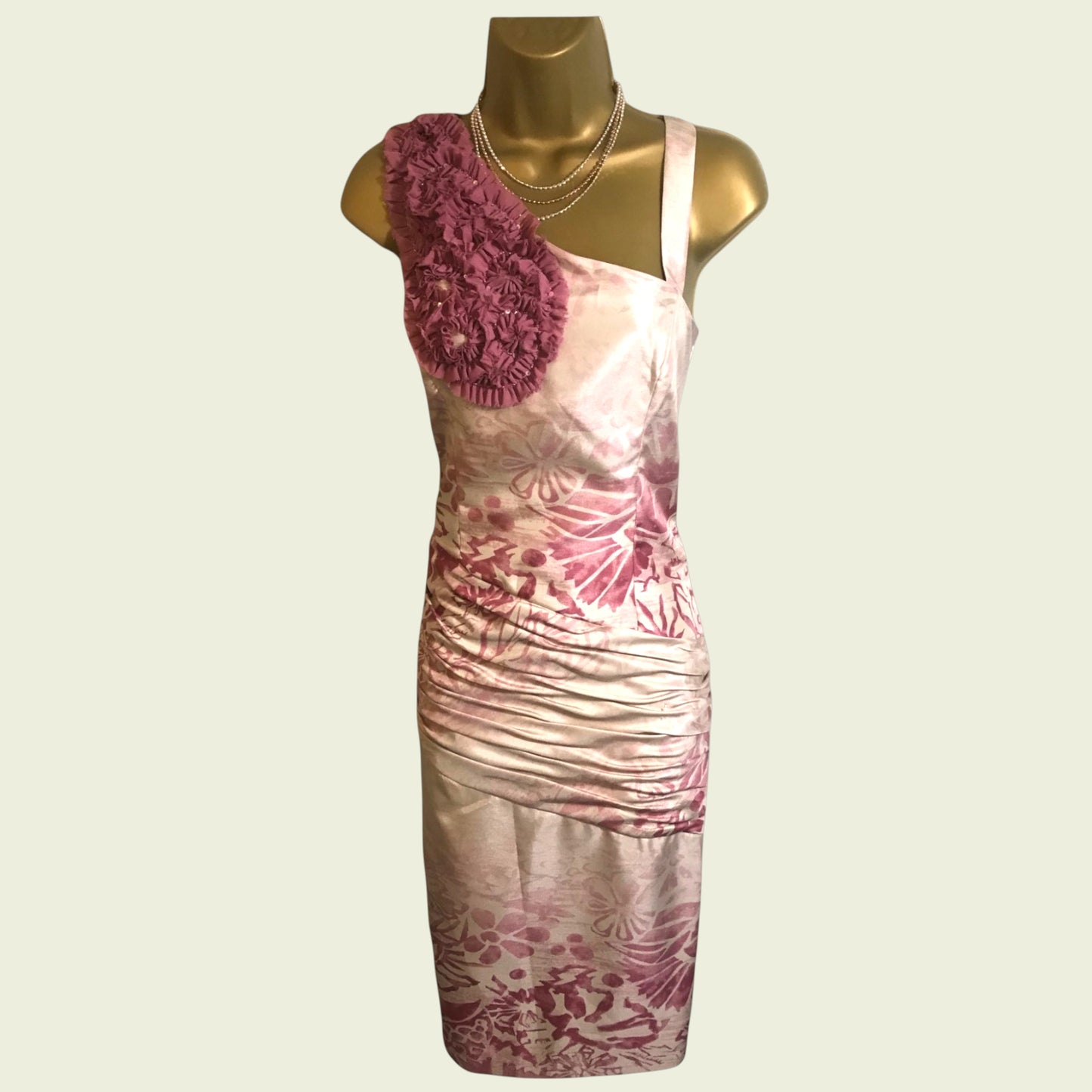 Mannequin with pink and cream floral dress on beige background