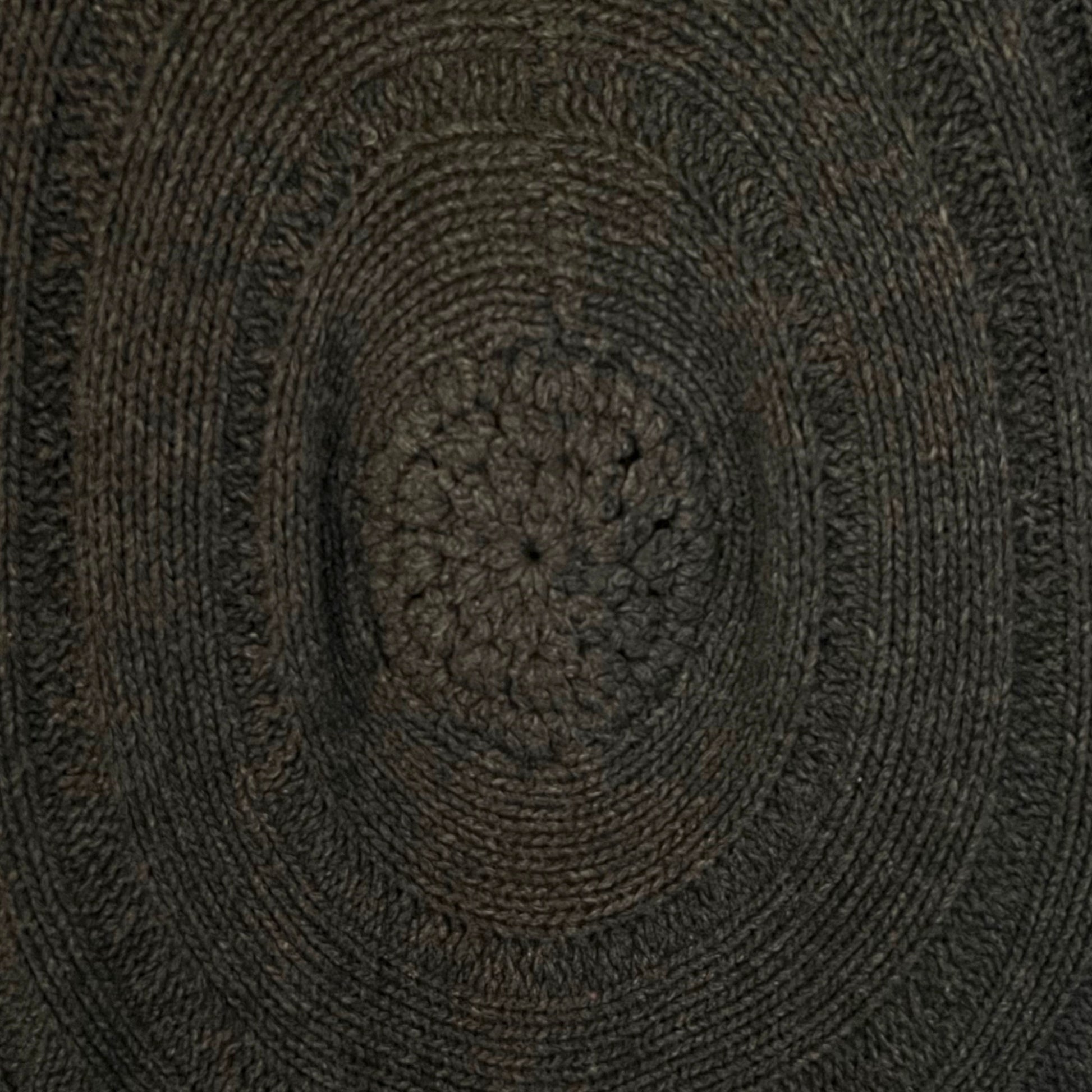 Close-up of a textured brown circular design with concentric patterns on brown cardigan