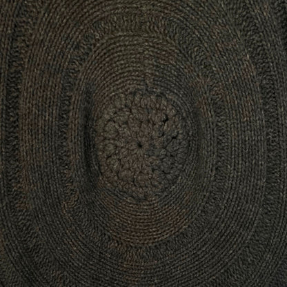 Close-up of a textured brown circular design with concentric patterns on brown cardigan