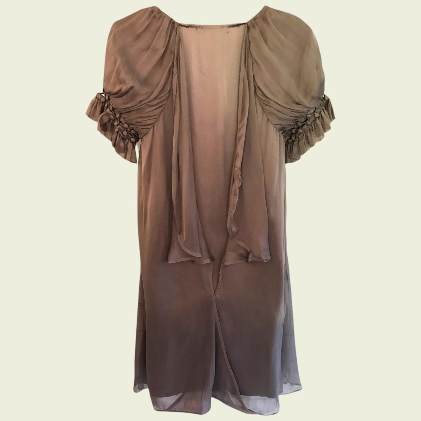 Brown dress with ruffled sleeves on a beige background
