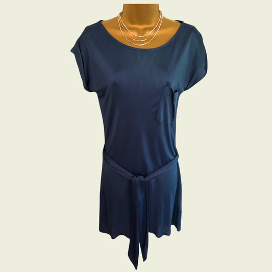 Mannequin wearing a blue silk top on beige background