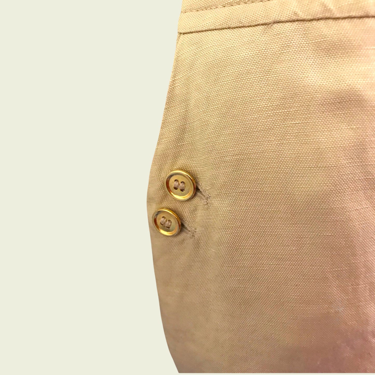 Button detail on tan skirt on beige background