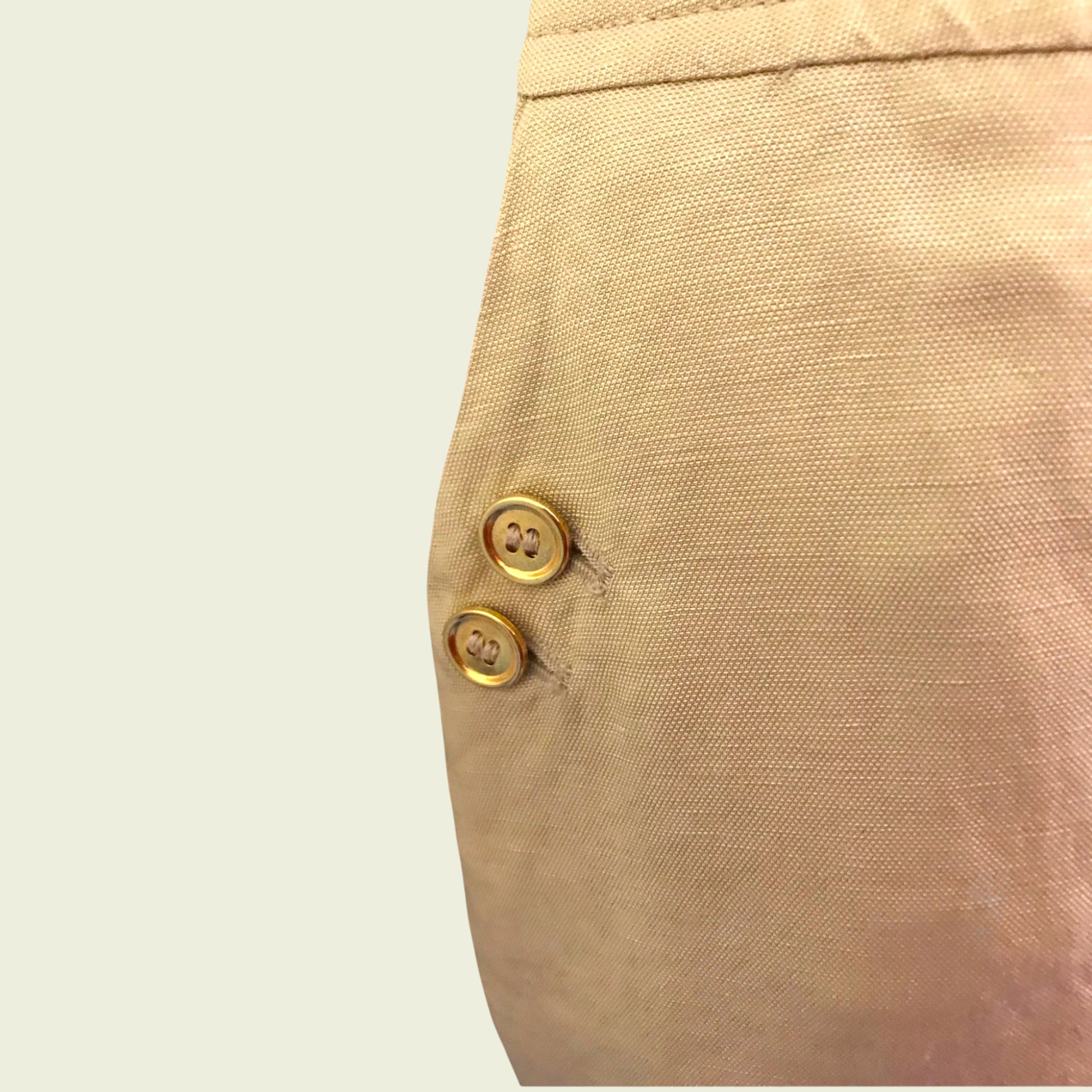 Button detail on tan skirt on beige background
