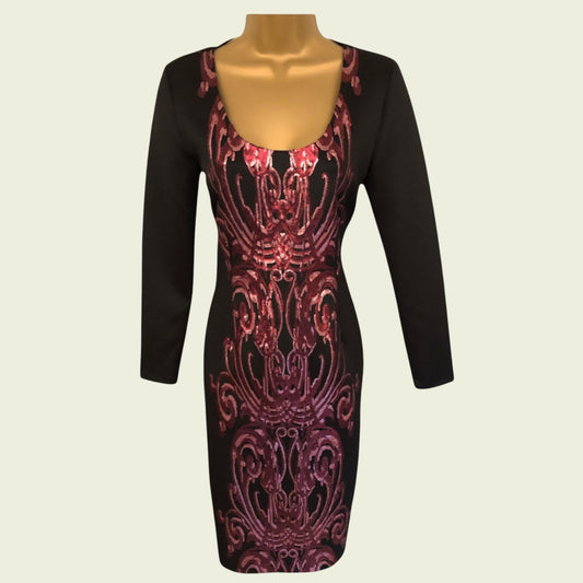 Black dress with red pattern on a mannequin against a beige background