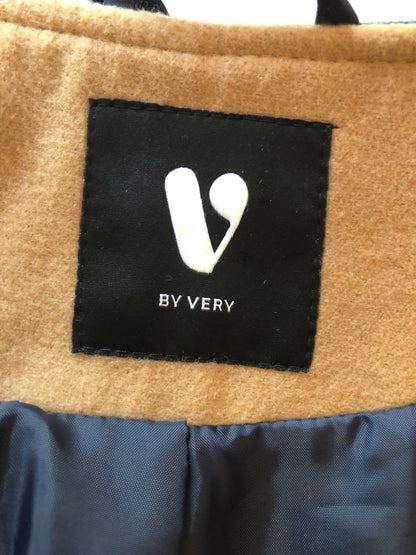 Close-up of a brown fabric surface with a black label featuring a white logo and text.