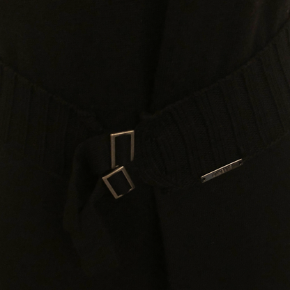 Close-up of a black garment with a belt and square buckle.