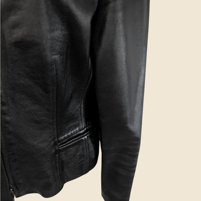 Close-up of a black leather jacket on a beige background