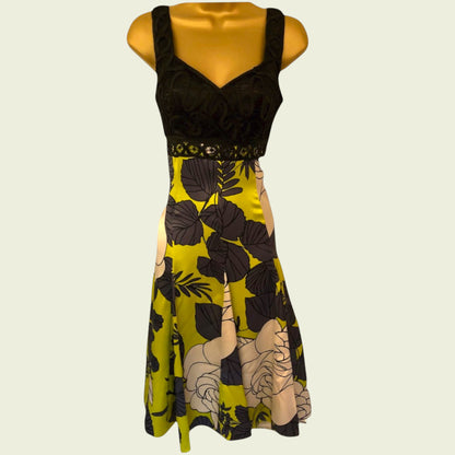 Mannequin wearing a black and yellow floral dress on a beige background