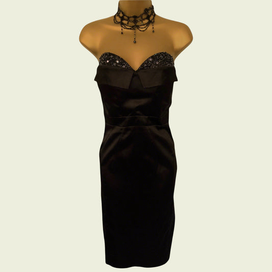 Black strapless dress on a mannequin with a beige background