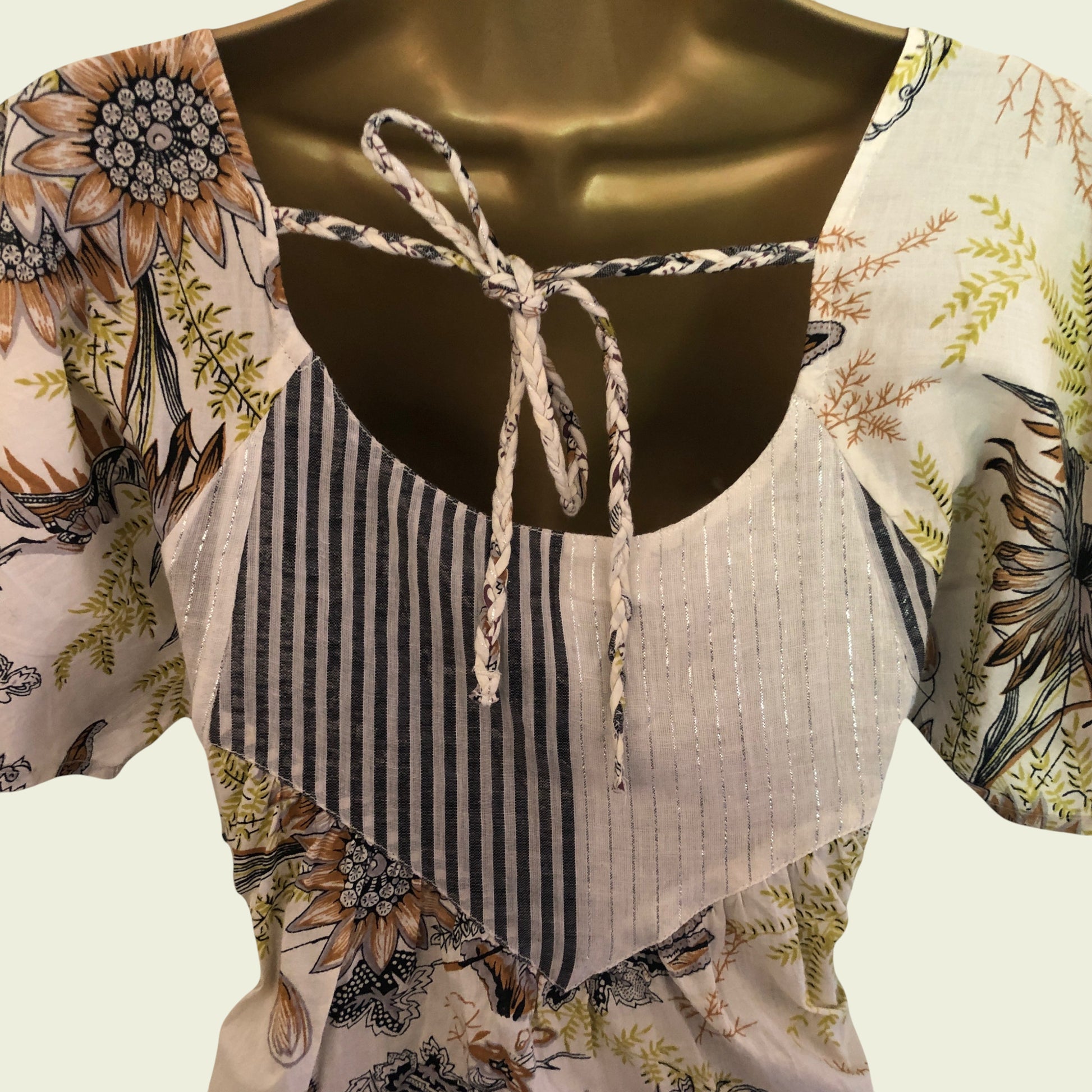 Close-up of a floral top with a striped bodice on a white background