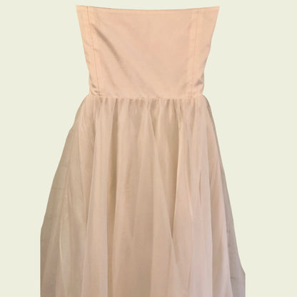 Mannequin wearing cream organza prom dress on beige background