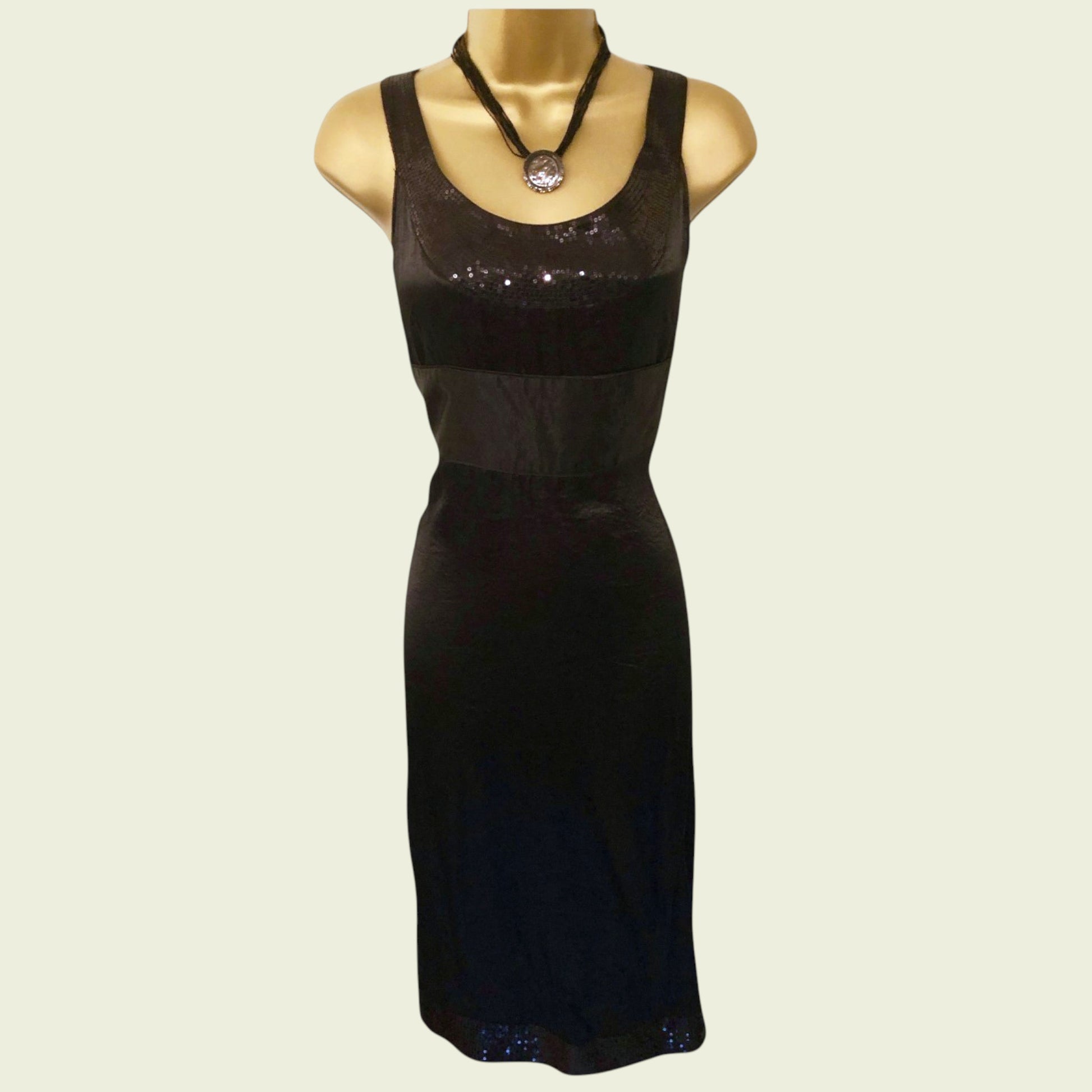 Black dress on a mannequin with a plain background