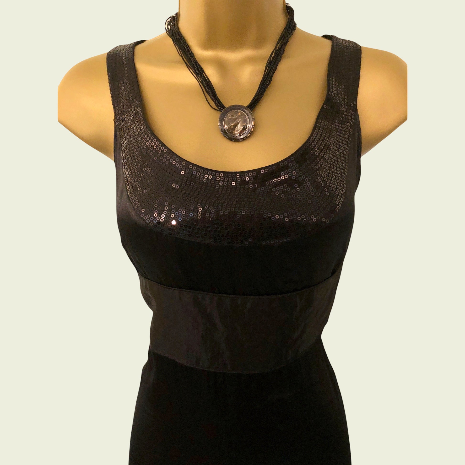 Black sequined top on a mannequin with a plain background