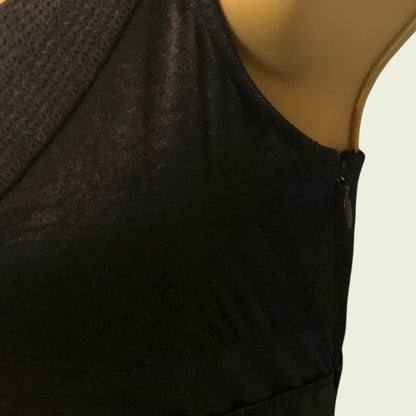 Black sleeveless top showing side zip on a mannequin with a beige background