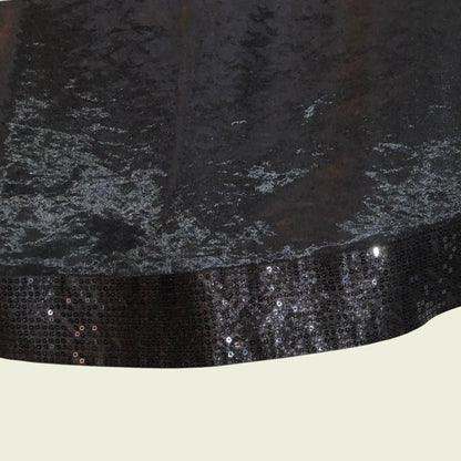 Black sequined trim on a garment with a neutral background