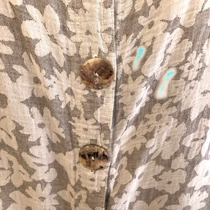 Close-up of a floral-patterned fabric with buttons on a textured background