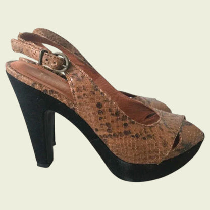 Side view of brown open-toe sandals with snake print on a light background