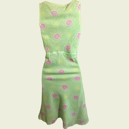 Green dress with pink floral pattern on a beige background