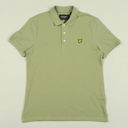 Green polo shirt with a brand logo on a light beige background