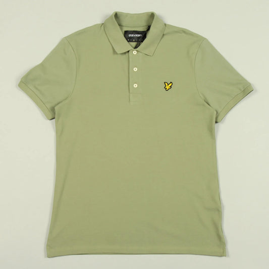 Green polo shirt with a brand logo on a light beige background