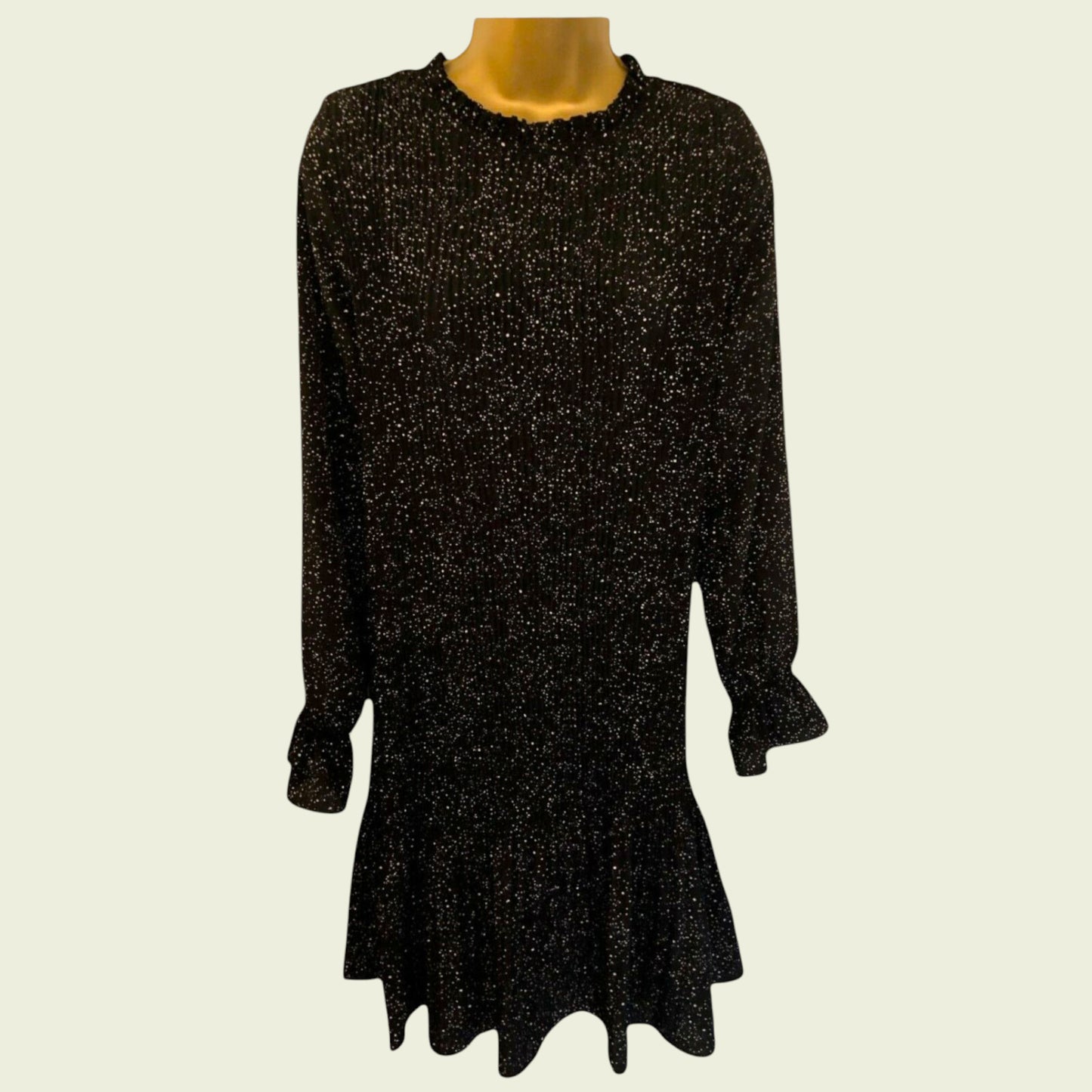 Black and white polka dot pleated dress on beige background