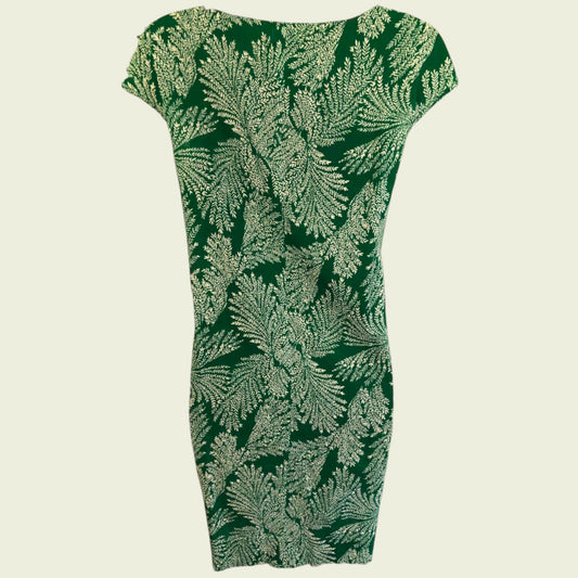 Green dress with leaf pattern on a beige background