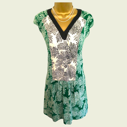 Green patterned dress on a mannequin against a light background