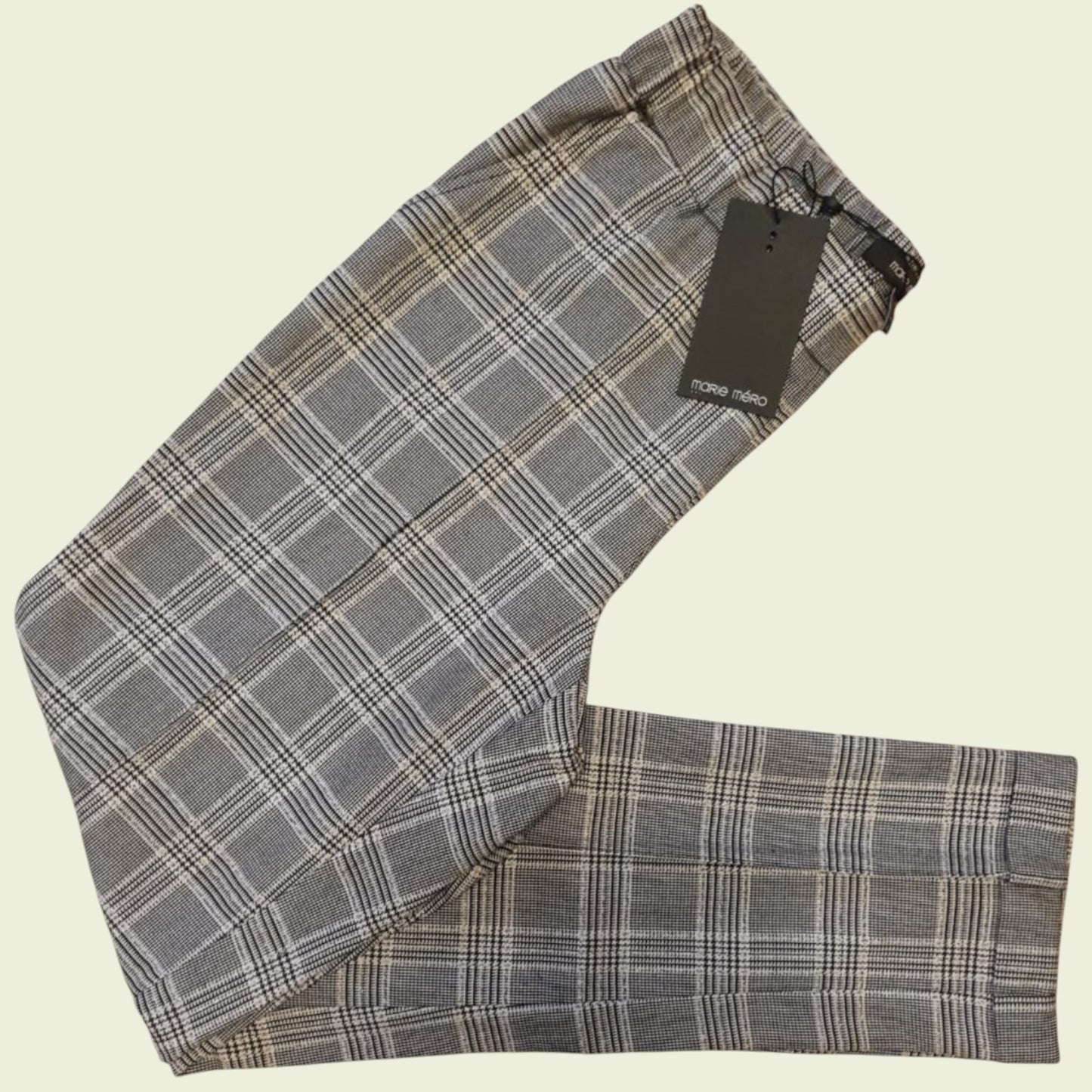 Plaid pants with a tag on a beige background