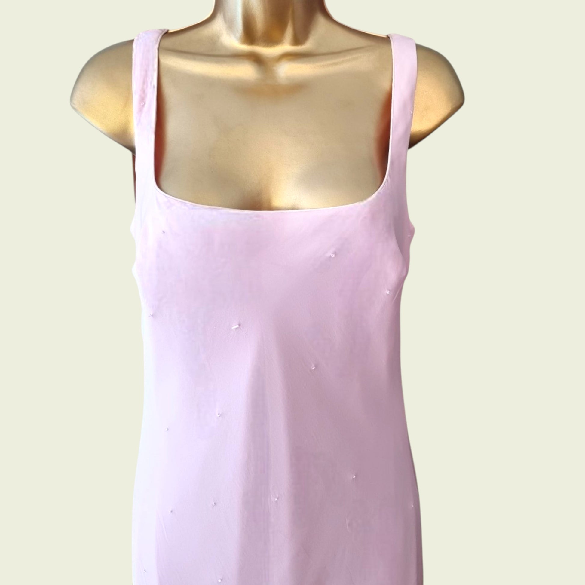 Close up of pink dress on a mannequin against a light background