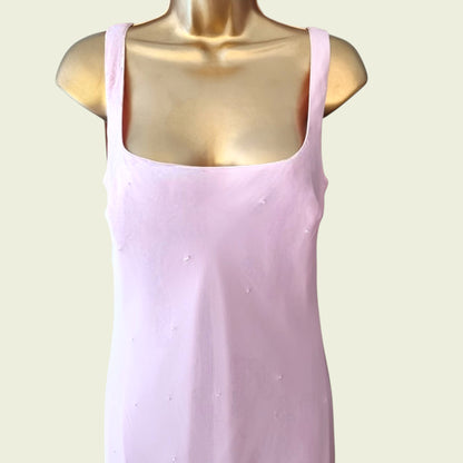 Close up of pink dress on a mannequin against a light background