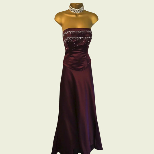 Burgundy evening gown on a mannequin against a beige background