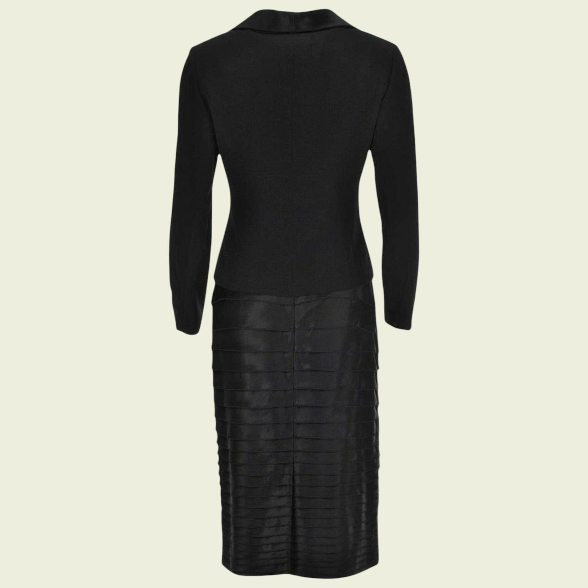 Black suit with long sleeves and a textured skirt on a beige background
