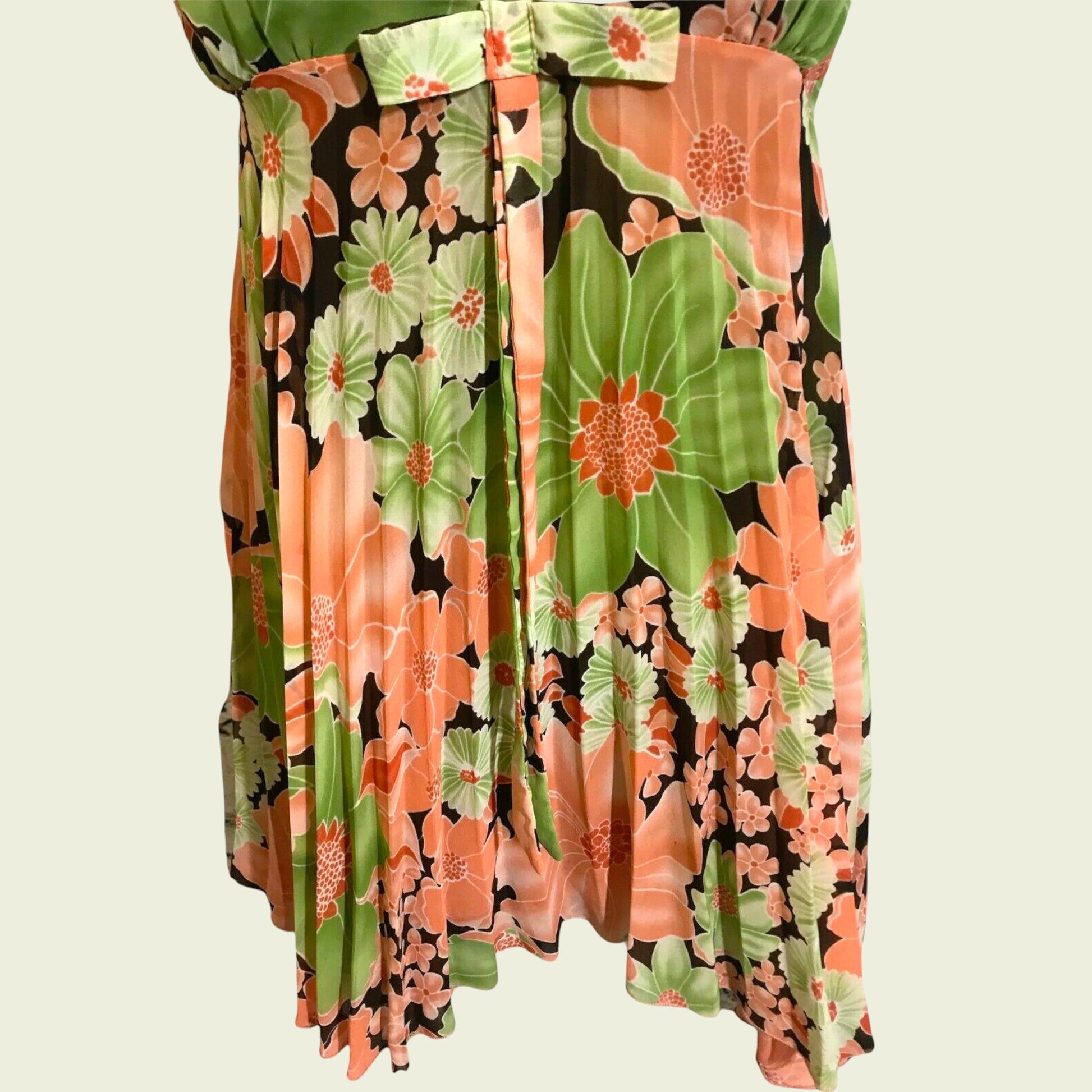 Bow and pleat detail on floral top on beige background