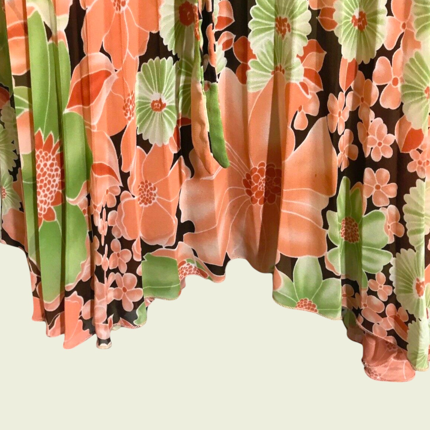 Floral patterned fabric with orange and green flowers on a brown background