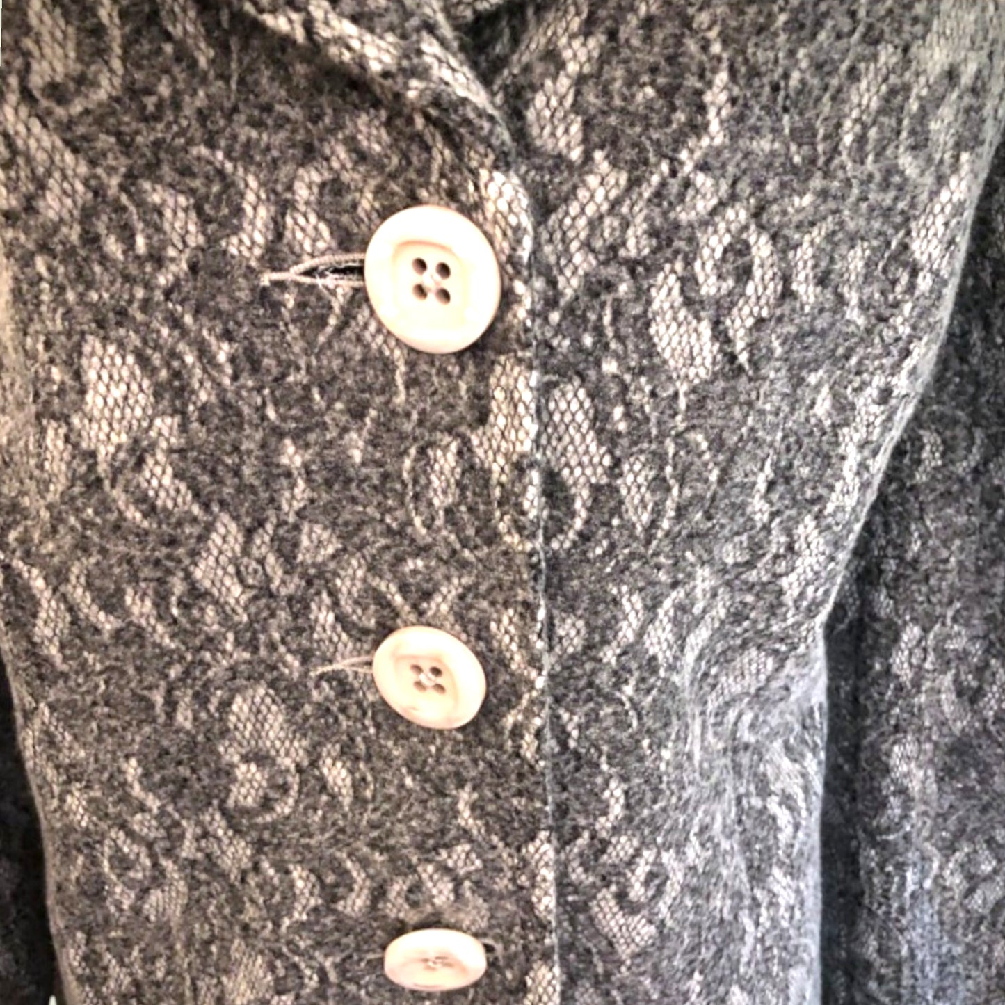 Close-up of a textured fabric with buttons on a garment