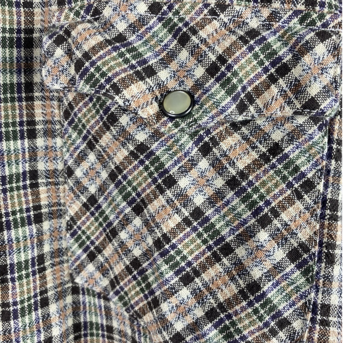 Close-up of a plaid fabric with a button in the center