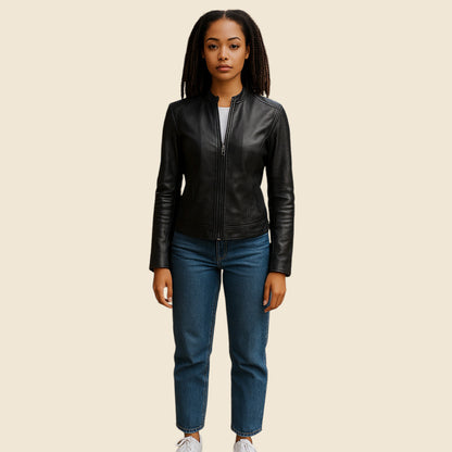 Person wearing a black leather jacket and blue jeans on a beige background
