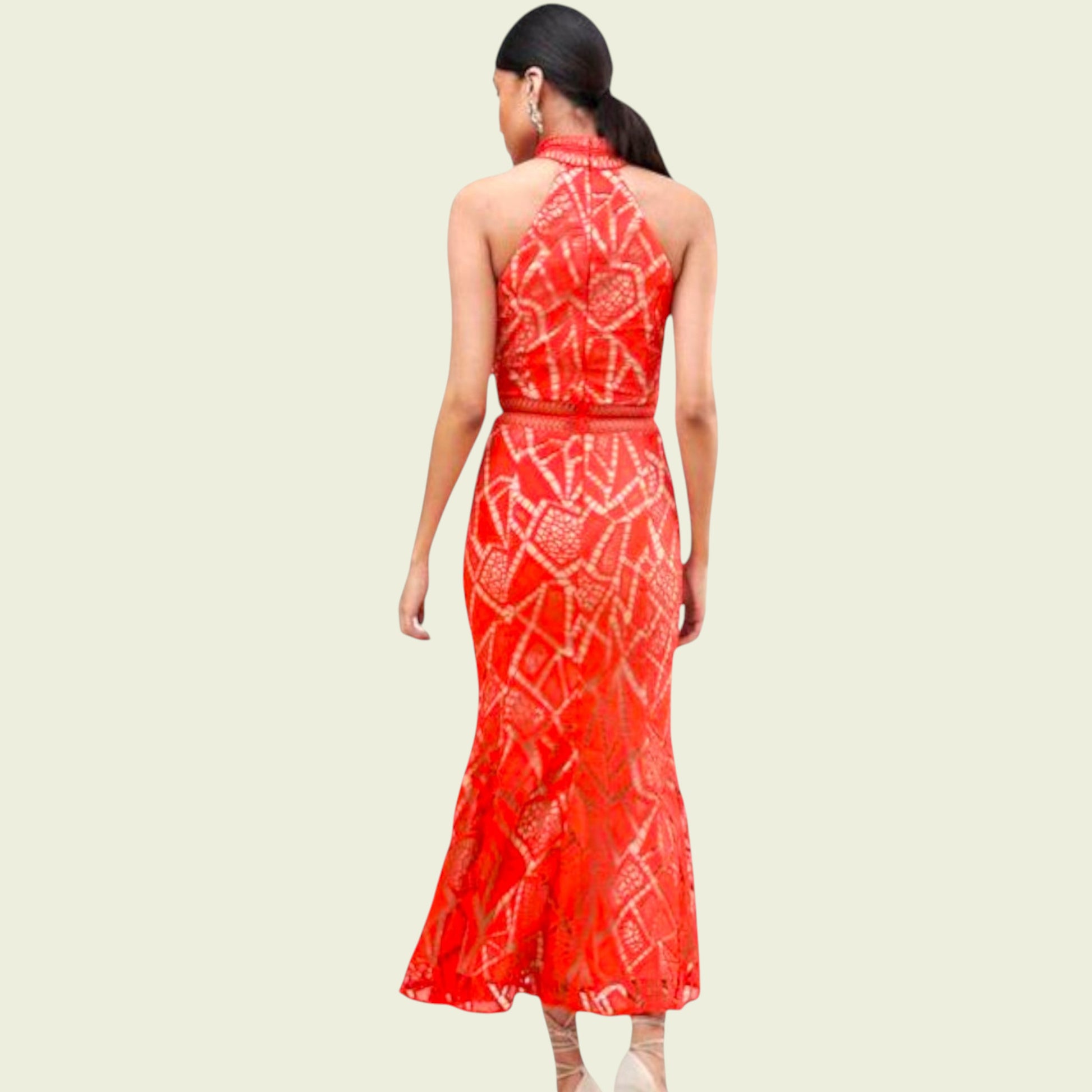 Woman wearing a red patterned dress on a beige background