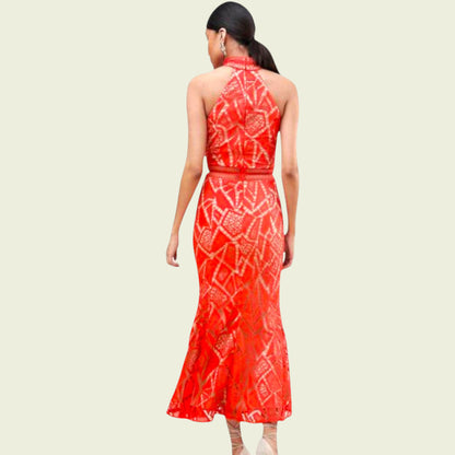 Woman wearing a red patterned dress on a beige background