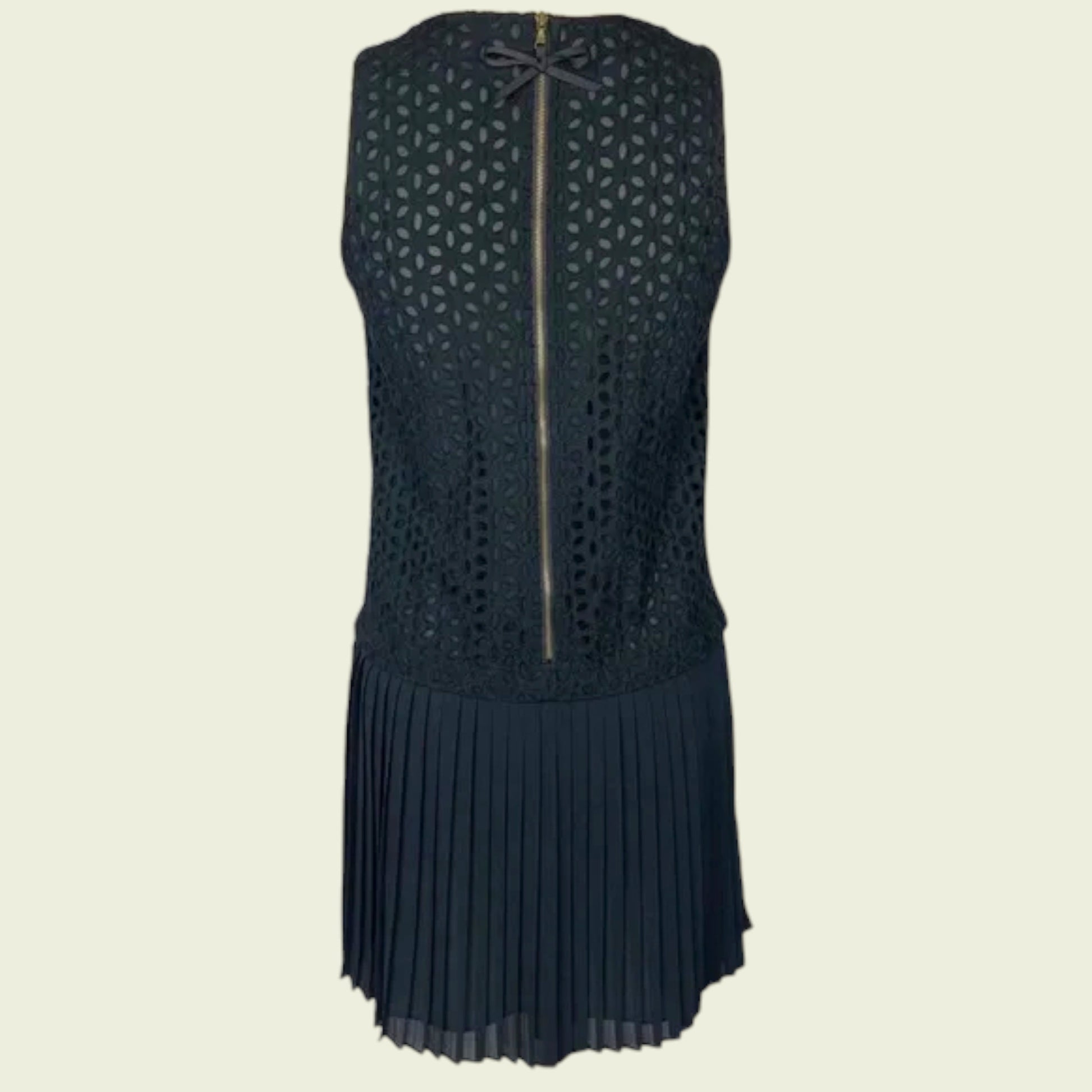 Black sleeveless dress with geometric pattern and pleated skirt on a beige background