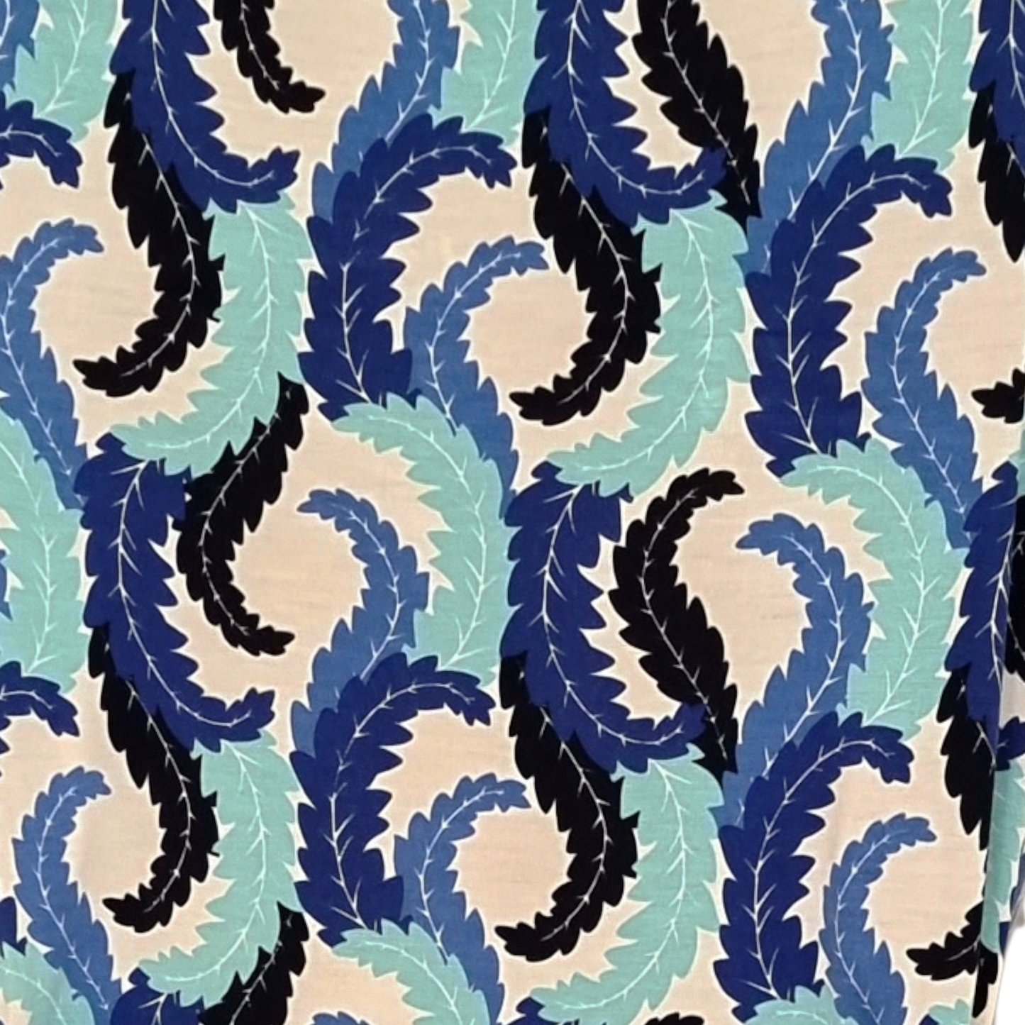 Pattern of blue, black, and green leaves on a beige background