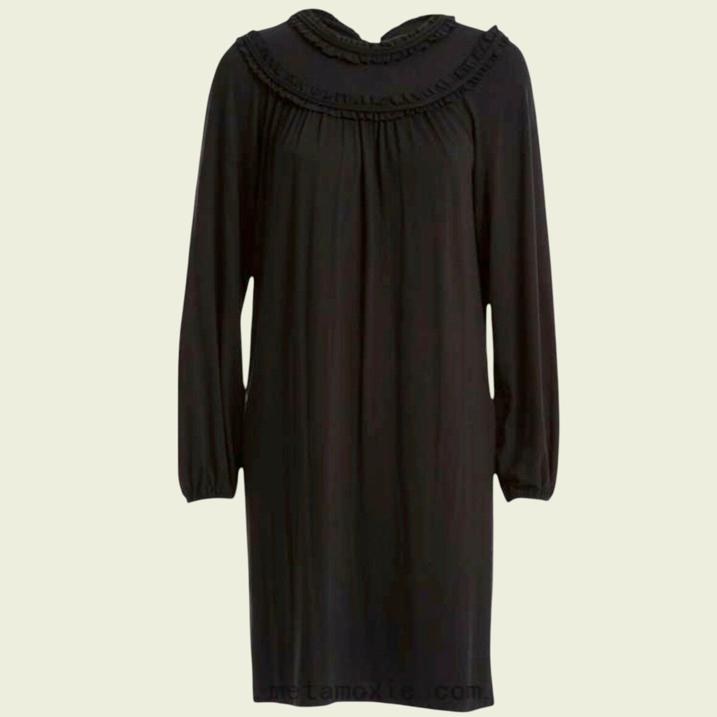 Black dress with a ruffled neckline on a beige background