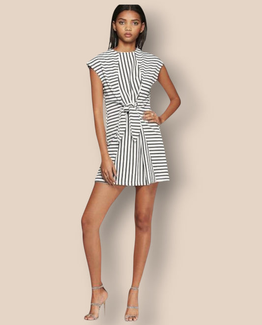 Woman wearing a black and white striped dress on a beige background