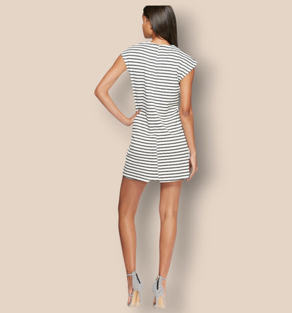 Woman wearing a black and white striped dress on a beige background
