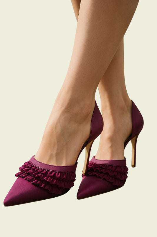 Purple high-heeled shoes with ruffles worn by a person on a beige background