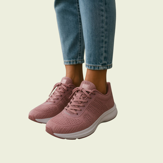 Pink sneakers worn with blue jeans on a beige background