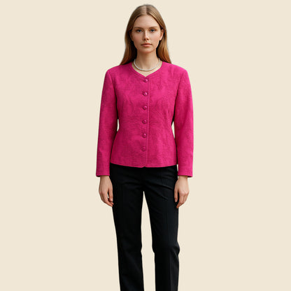 Woman wearing a pink jacket and black pants on a beige background